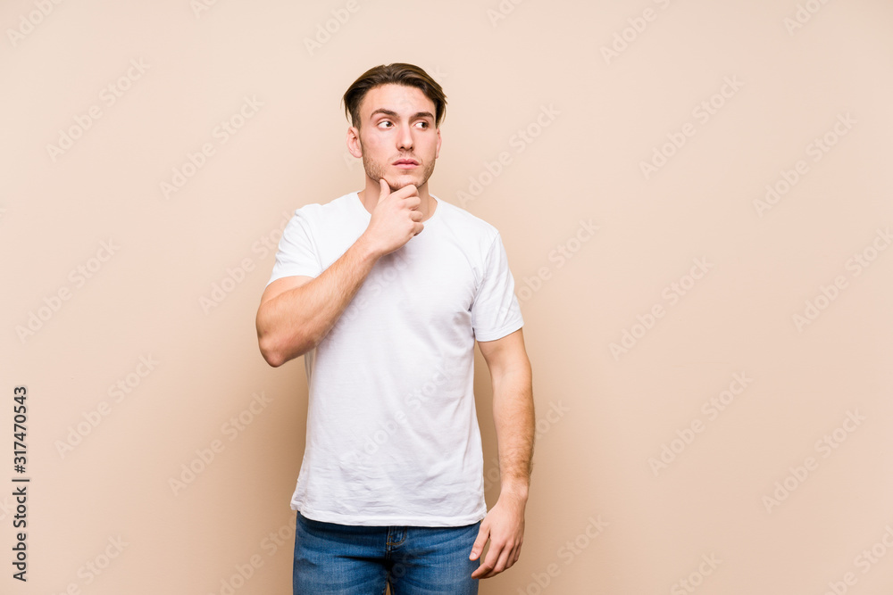 Young caucasian man posing isolated looking sideways with doubtful and skeptical expression. Young caucasian man posing isolated looking sideways with doubtful and skeptical expression.