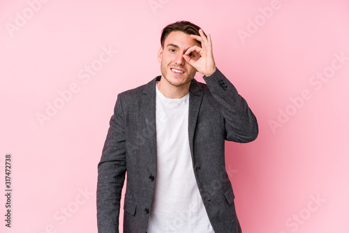 Young caucasian business man posing isolated excited keeping ok gesture on eye. © Asier