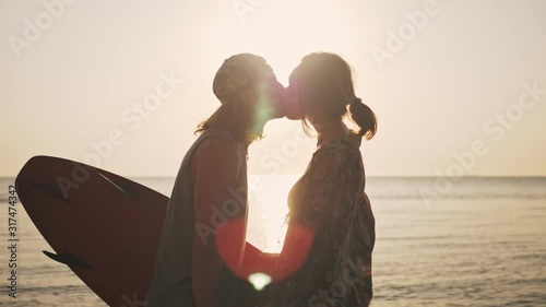 A good-looking young couple man and woman are kissing at the beach