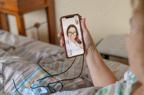 An elderly woman talking to the doctor on the phone. A pensioner suffers from a respiratory illness and makes a video call to the therapist. Online consultation