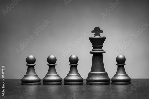 Black king chess piece with four pawns