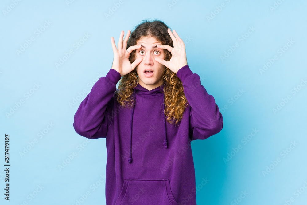 Long hair man posing isolated keeping eyes opened to find a success opportunity. Long hair man posing isolated keeping eyes opened to find a success opportunity.