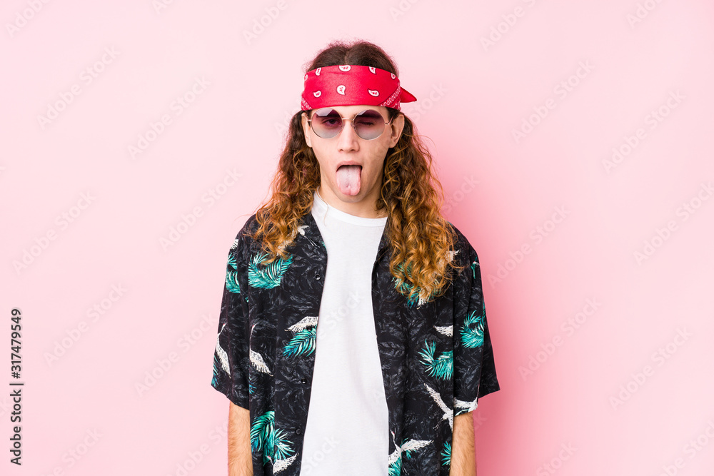 Young hippie caucasian man isolated funny and friendly sticking out tongue. Young hippie caucasian man isolated funny and friendly sticking out tongue.