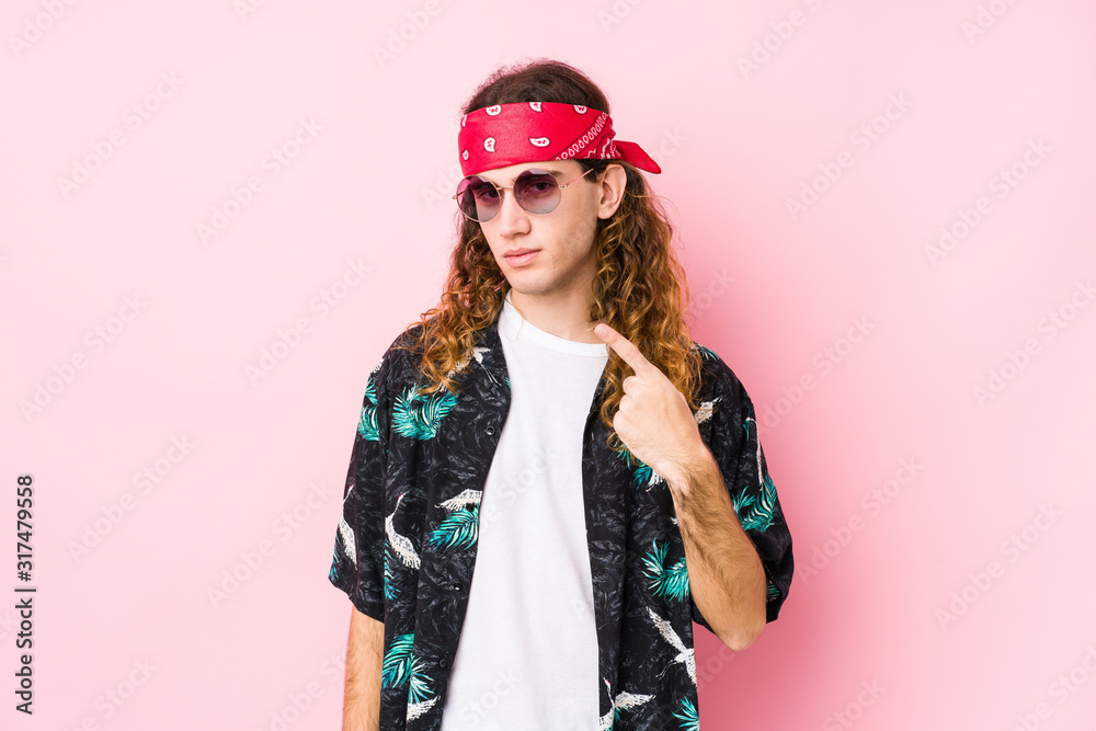 Young hippie caucasian man isolated pointing with finger at you as if inviting come closer.
