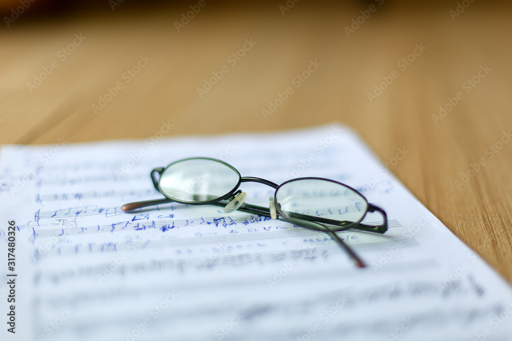 musical manuscript with notes, glasses in the background musical manuscript with notes, glasses in the background
