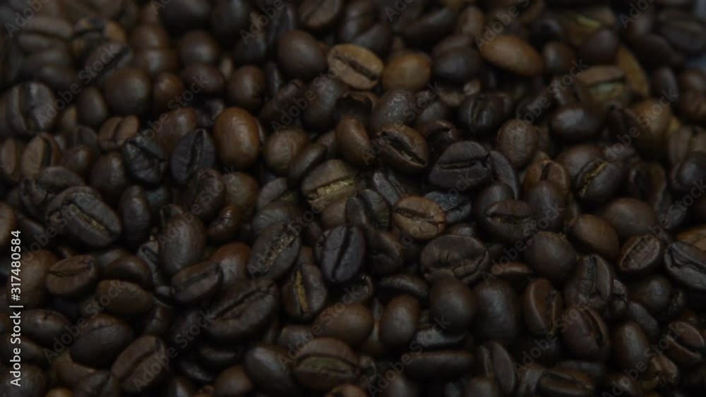 Dark Coffee Grains. Rotating and falling. Coffee beans. Close up of seeds of coffee. Beautiful seeds of coffee. Dark Coffee Grains. Rotating and falling. Coffee beans. Close up of seeds of coffee. Beautiful seeds of coffee.