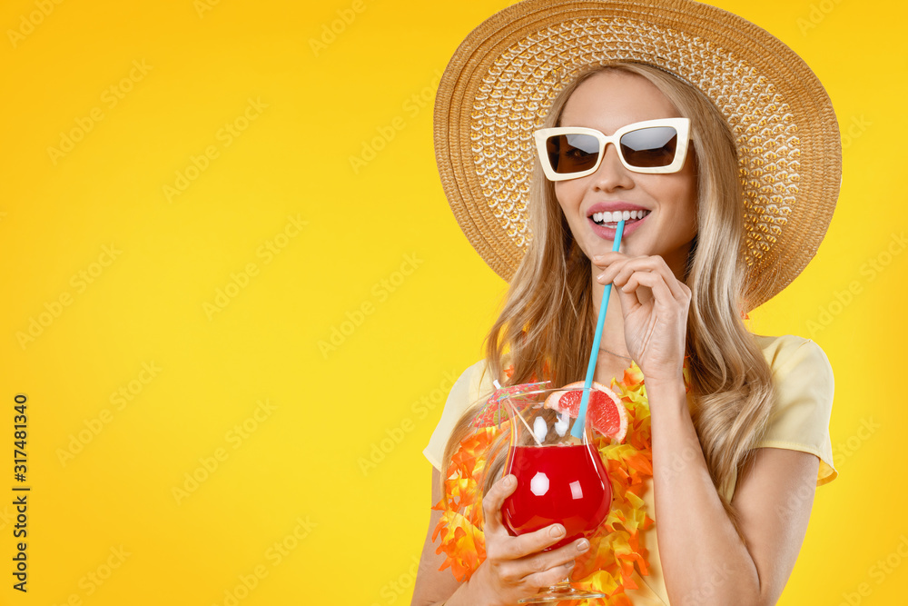 Beautiful smiling woman in summer dress with cocktail isolated on yellow background Beautiful smiling woman in summer dress with cocktail isolated on yellow background
