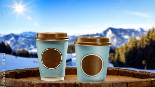 Fresh hot coffee on retro barrel and winter landscape of mountains.Copy space and sunny day.Ski time. 
