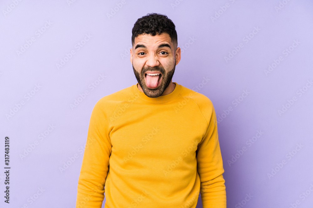 Fototapeta premium Young mixed race arabic man isolated funny and friendly sticking out tongue.