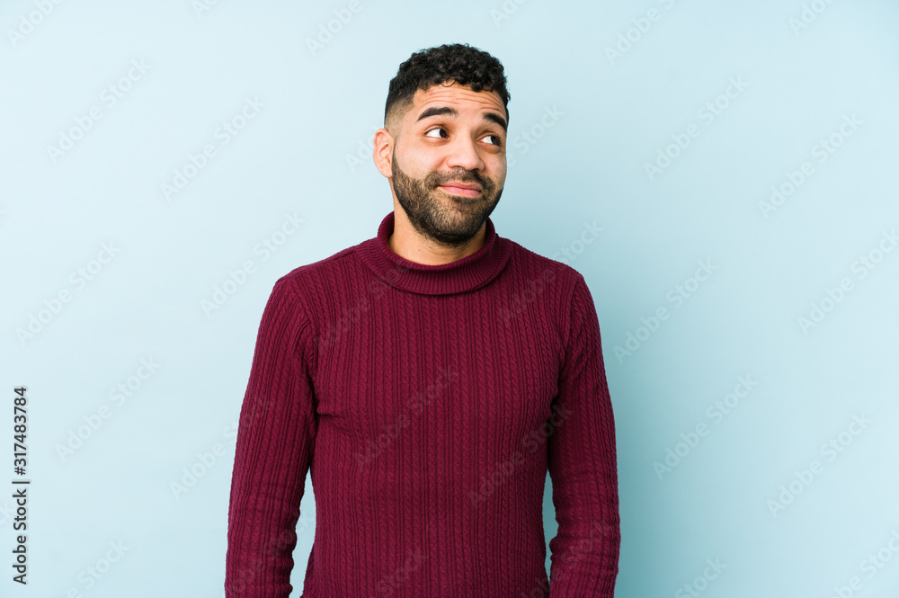 Young mixed race arabic man isolated dreaming of achieving goals and purposes Young mixed race arabic man isolated dreaming of achieving goals and purposes