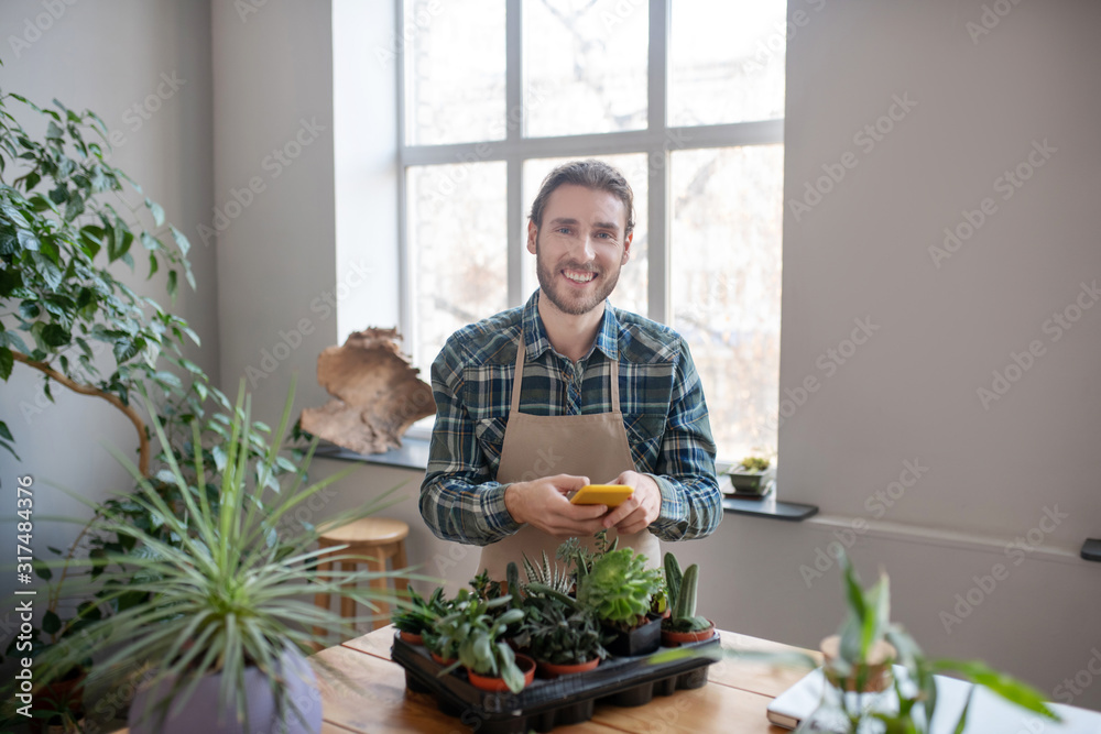Smiling man planting succulents for online store