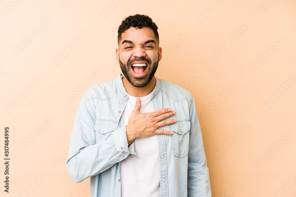 Young mixed race arabic man isolated laughs out loudly keeping hand on chest. Young mixed race arabic man isolated laughs out loudly keeping hand on chest.