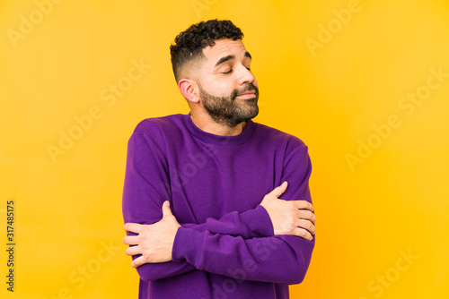 Young mixed race arabic man isolated hugs, smiling carefree and happy.