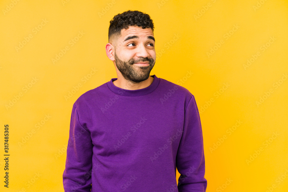 Young mixed race arabic man isolated dreaming of achieving goals and purposes Young mixed race arabic man isolated dreaming of achieving goals and purposes