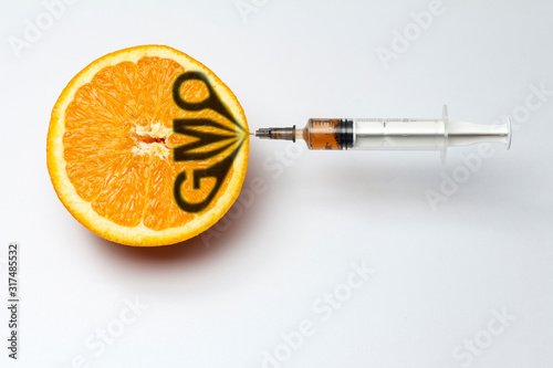 orange and syringe in it, gmo concept photo