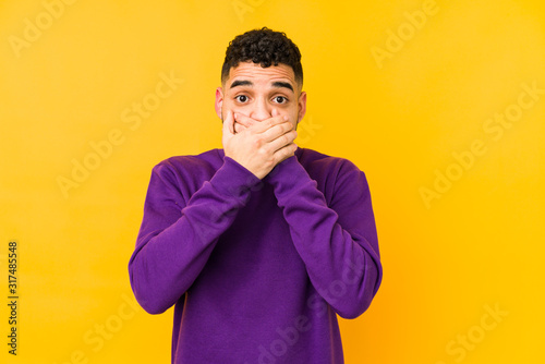 Young mixed race arabic man isolated shocked covering mouth with hands. © Asier