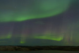 Aurora borealis over the hills. At night in the sky in the north.