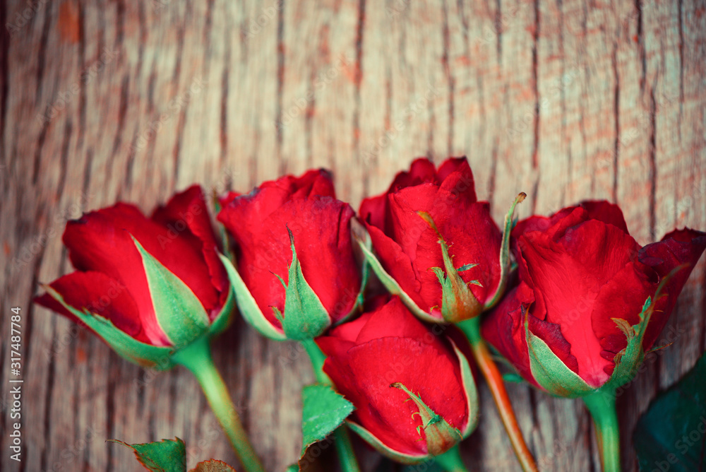 Red roses flower bouquet on rustic wood background - flowers rose petals romantic love valentine day concept Red roses flower bouquet on rustic wood background - flowers rose petals romantic love valentine day concept