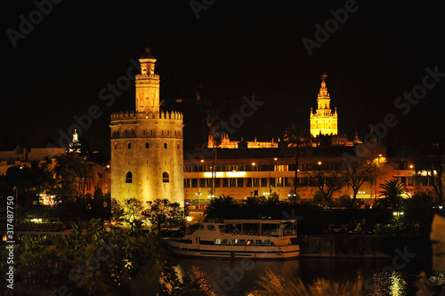 Cityscape of Seville by night with the Torre del Oro (Golden Tower), the Giralda tower and Guadalquivir river, Andalusia, Spain