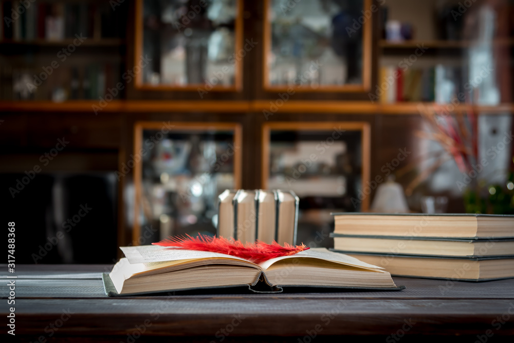 Fototapeta premium Open book with a bookmark on a wooden table.
