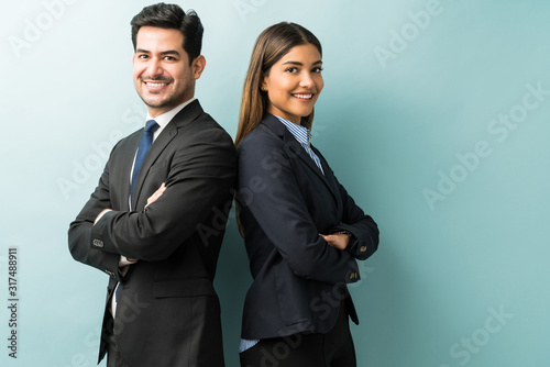 Business Colleagues Standing With Arms Crossed In Studio photo