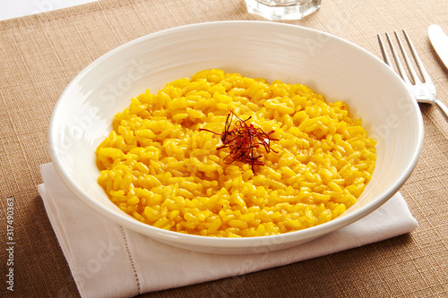 Bowl of yellow risotto rice with saffron threads photo