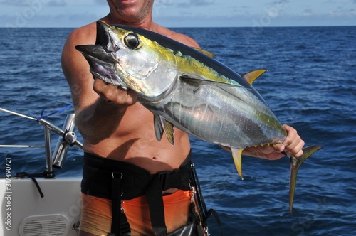 Big Game Fishing Fisherman shows Yellowfin Catch on Katamaran