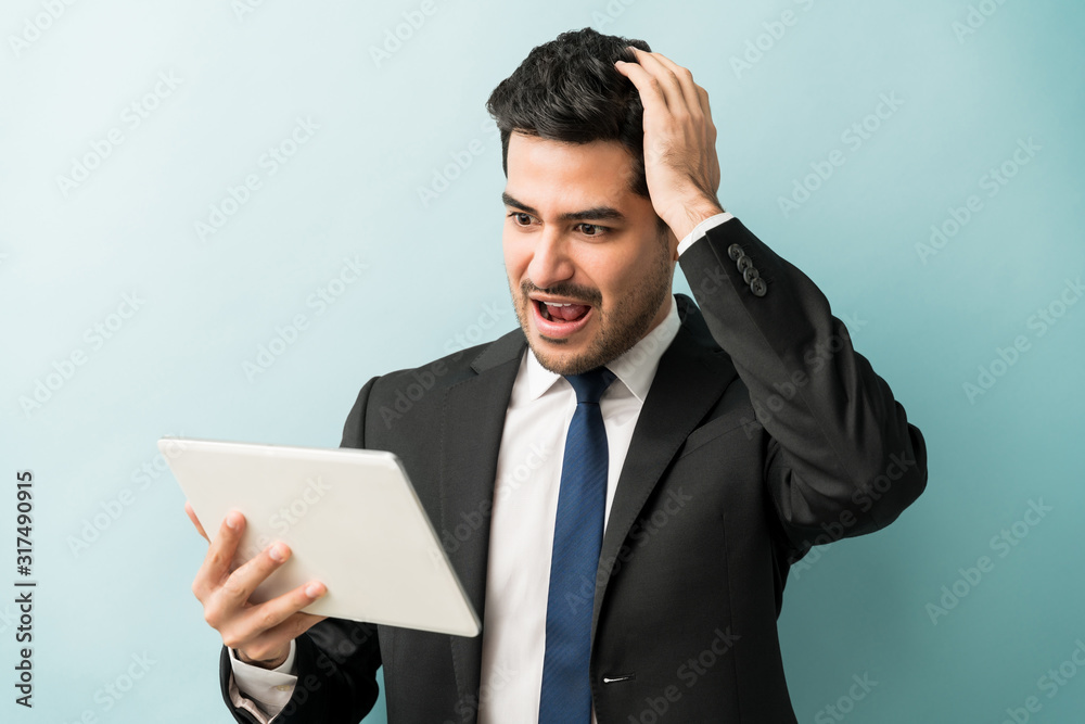 Businessman Looking At Shocking News On Wireless Computer Businessman Looking At Shocking News On Wireless Computer
