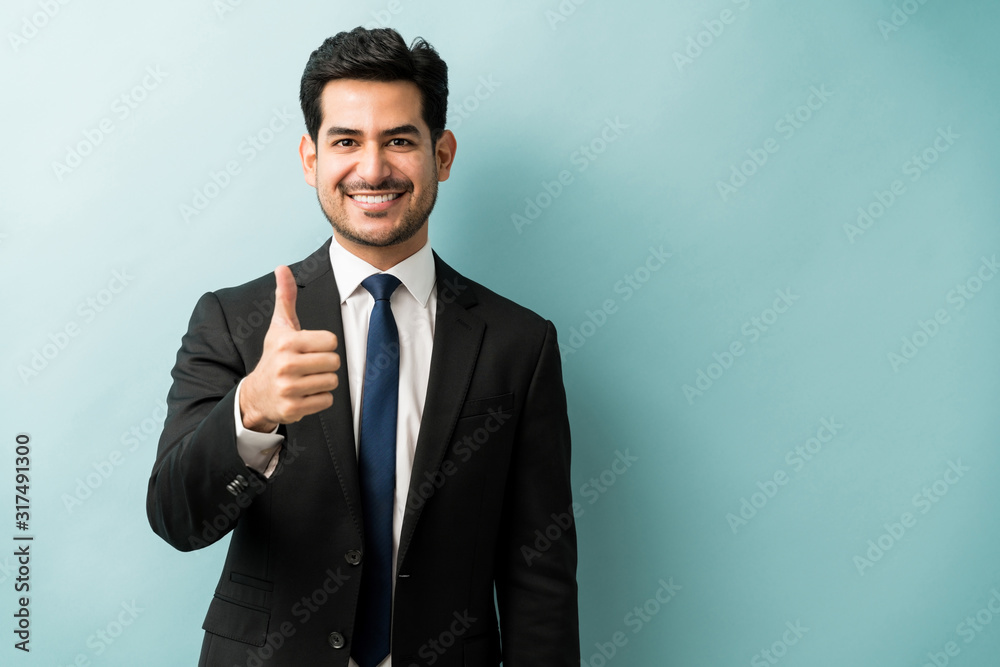 Portrait Of Businessman Showing Hand Sign In Studio Portrait Of Businessman Showing Hand Sign In Studio