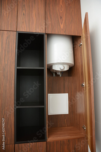 House hot water boiler hidden in the bathroom wardrope with surface mounted electric meter box photo