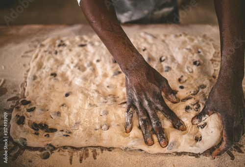 African man making bread with raw dough