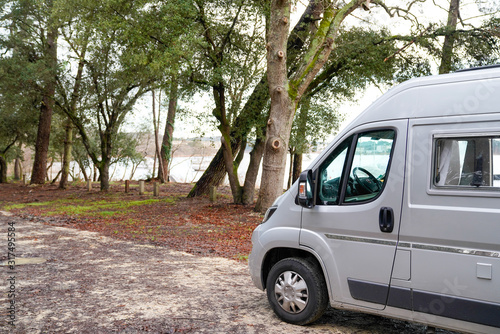 motorhome at lac d'hourtin under the pine trees of the forest in vanlife concept camper van © OceanProd