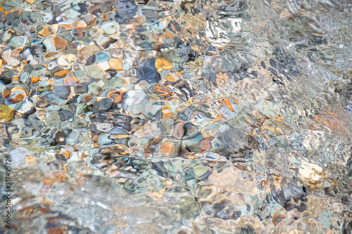 The clear water surface and pebbles photo