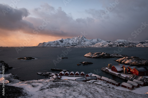 Typical lofoten islands view, fishermen cottages and fish factory with mountains in background. winter in north of norway. red cabins photo