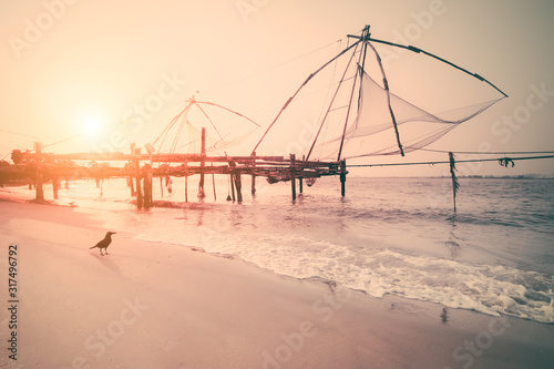 Sunset at tropical beach. Ocean coast landscape with chinese fishing nets silhouette at Cochin (Kochi). South India, Kerala, Kochin photo