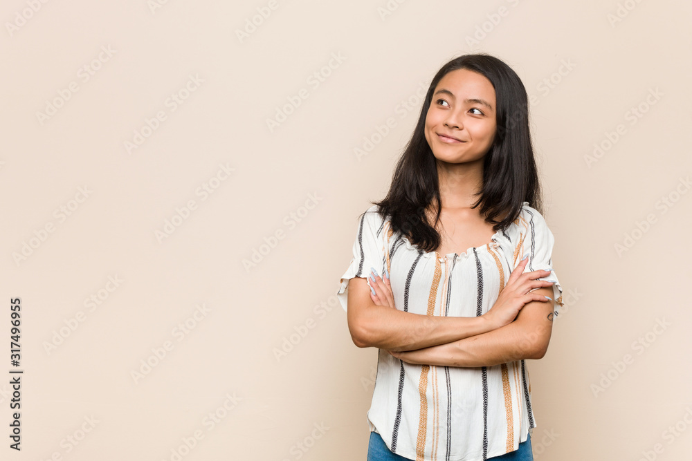 Young cute chinese teenager Young blonde woman wearing a coat against a pink background smiling confident with crossed arms. Young cute chinese teenager Young blonde woman wearing a coat against a pink background smiling confident with crossed arms.