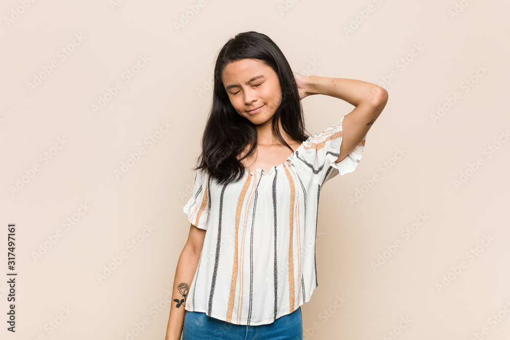 Young cute chinese teenager Young blonde woman wearing a coat against a pink background suffering neck pain due to sedentary lifestyle. Young cute chinese teenager Young blonde woman wearing a coat against a pink background suffering neck pain due to sedentary lifestyle.