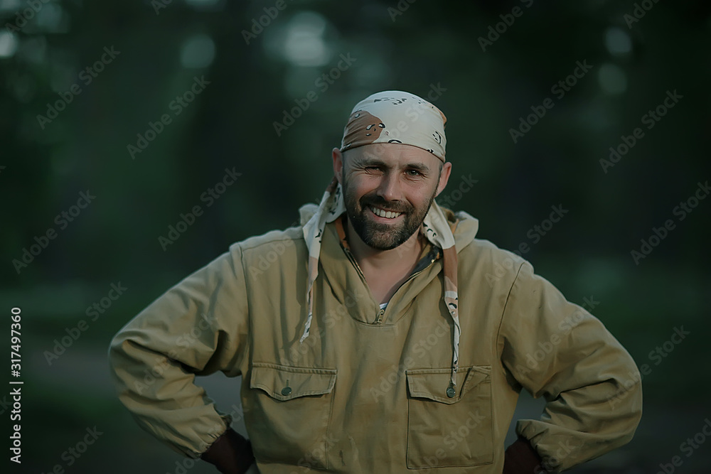 male hiker forester portrait, young man with beard trekking in the forest