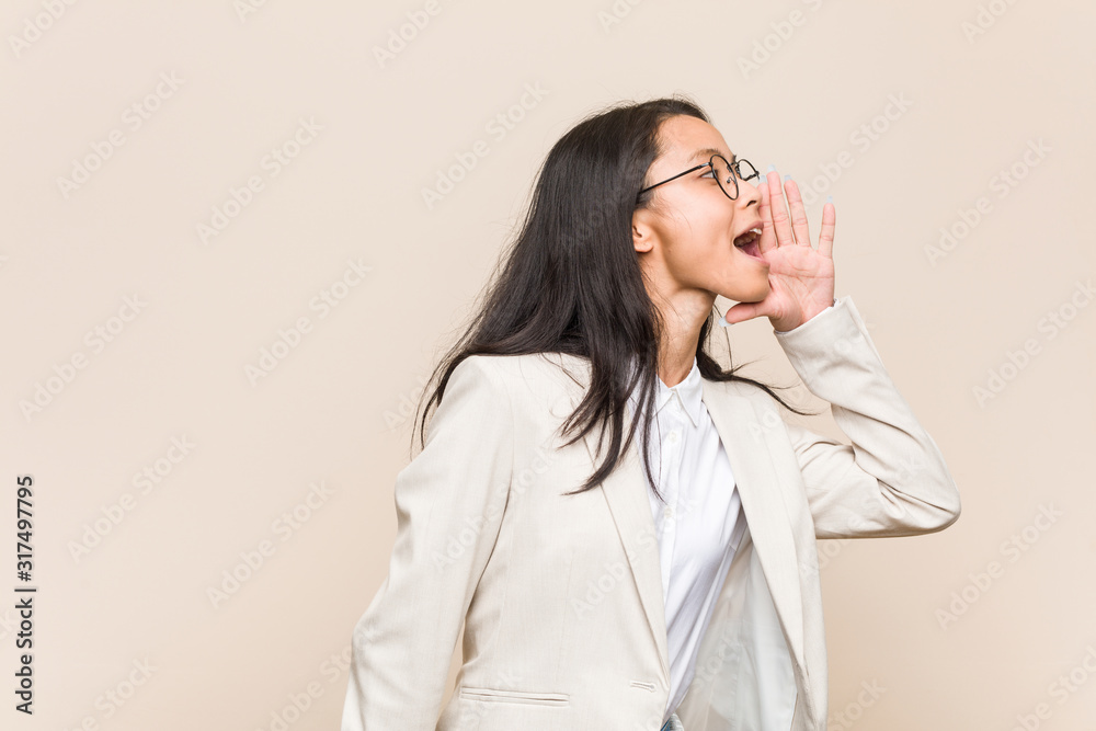 Young business chinese woman shouting and holding palm near opened mouth. Young business chinese woman shouting and holding palm near opened mouth.