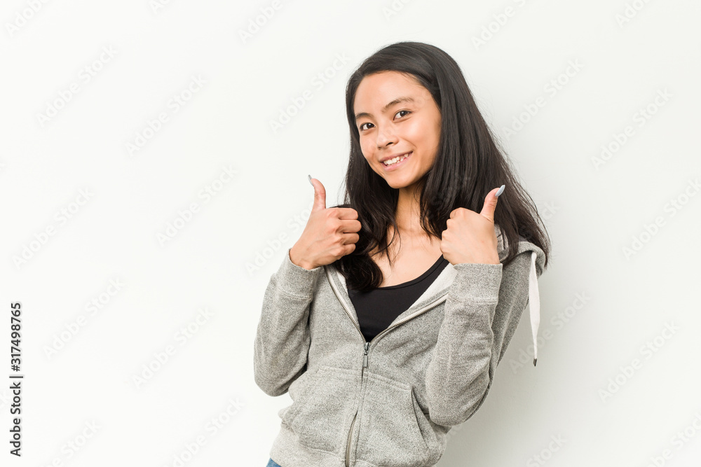 Young fitness chinese woman raising both thumbs up, smiling and confident. Young fitness chinese woman raising both thumbs up, smiling and confident.