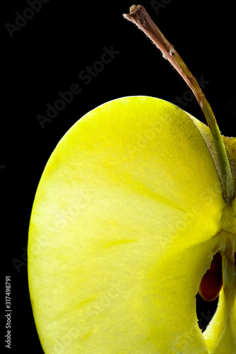 Macro of slim sliced of green apple on black background