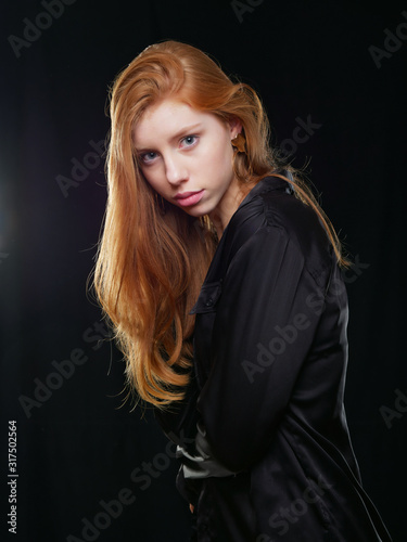 young girl with long red hair on a black background
