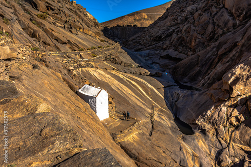 iglesia pequeña en un desfiladero de montañas de roca en el atardecer photo