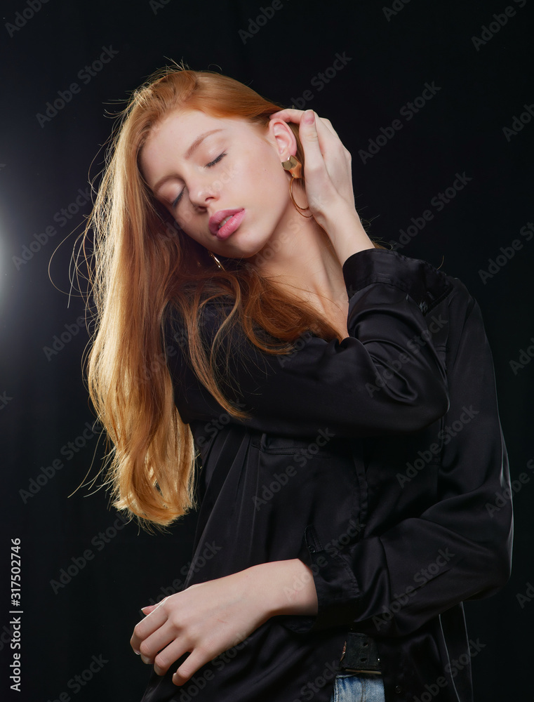 young girl with long red hair on a black background young girl with long red hair on a black background