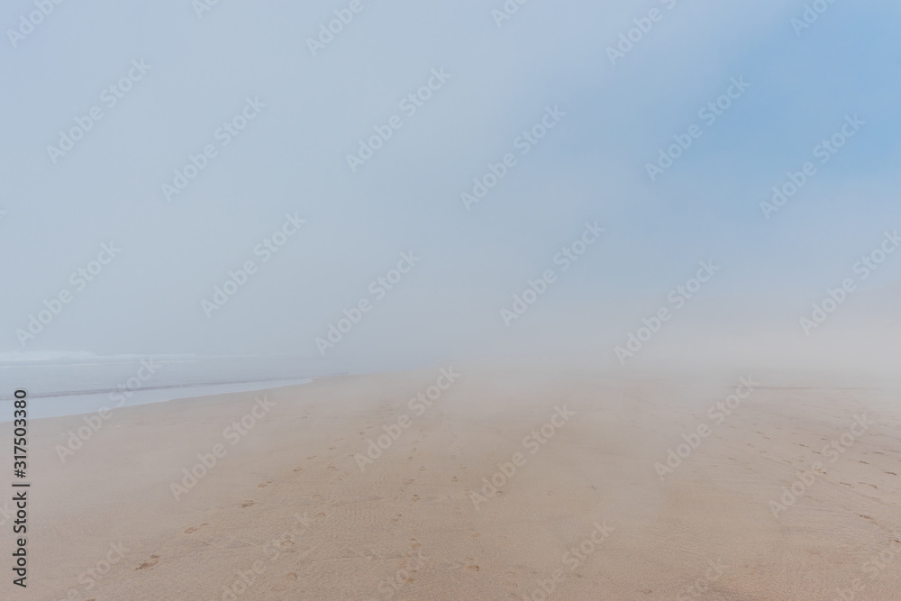 Empty wide sandy ocean beach in fog, soft pastel colors Empty wide sandy ocean beach in fog, soft pastel colors