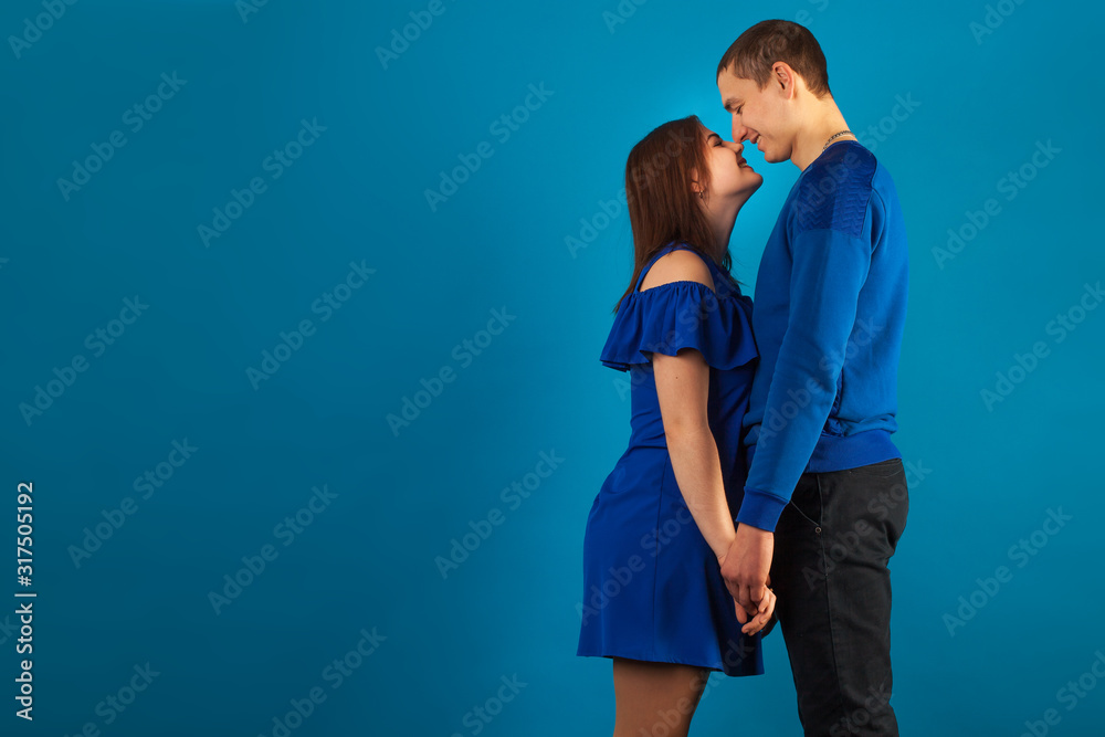 Naklejka premium young couple in love on a blue background with red balloons. Valentine's Day