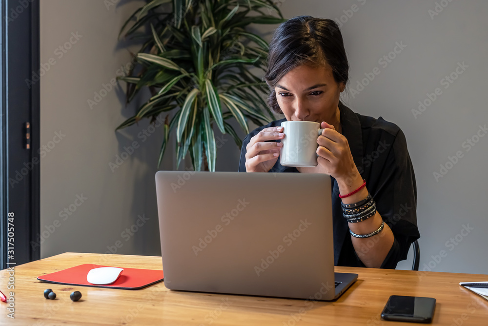 Young woman working online at home with laptop and documents Young woman working online at home with laptop and documents