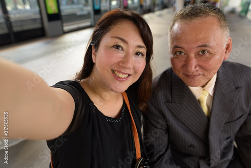 Mature Asian businessman and mature Asian woman exploring the city together