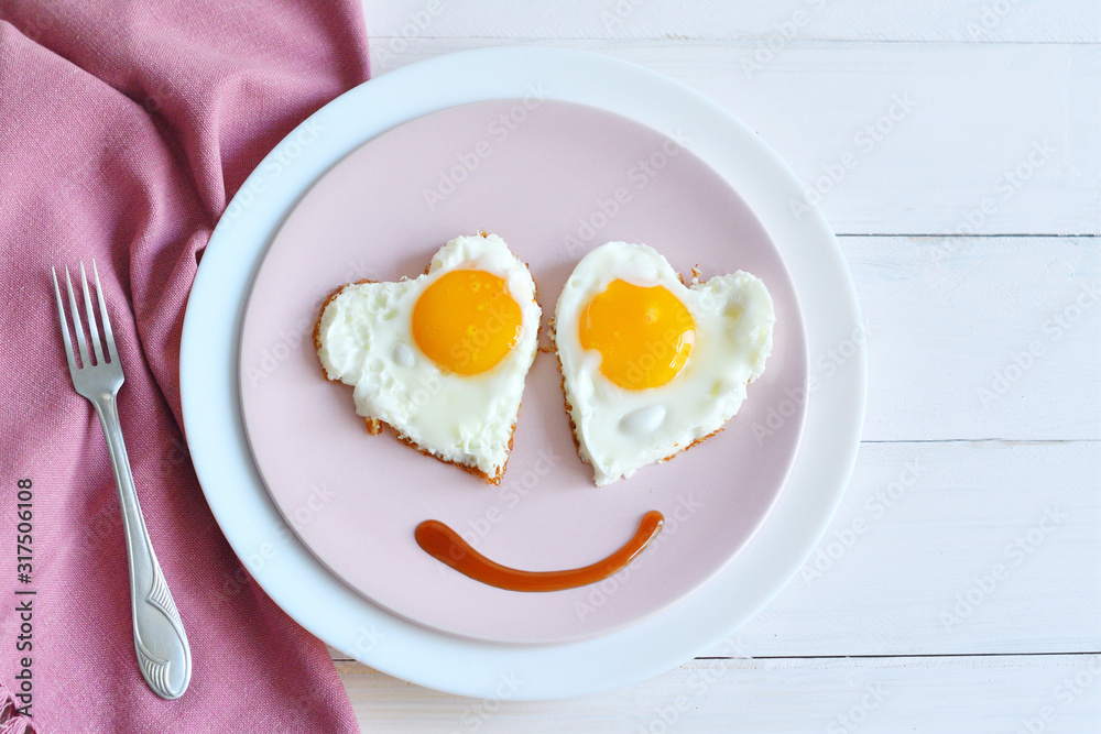 Two fried eggs on pink plate for healthy breakfast on wooden table. top view Two fried eggs on pink plate for healthy breakfast on wooden table. top view
