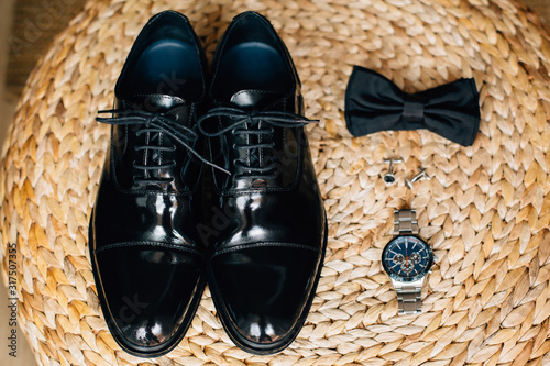 Stylish black bow tie cufflinks shoes and watches. Groom getting ready in morning before wedding. gentleman set